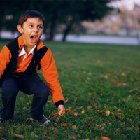boy outside in autumn jumping an dscreaming