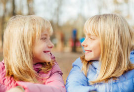 twin girls 10 years old smiling at each other