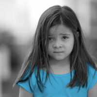 Portrait little girl with concerned emotion nervous child looking at camera