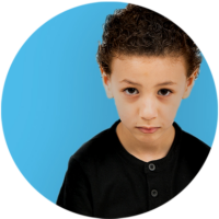 young boy curly hair staring at camera