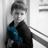 boy sad holding a teddy bear