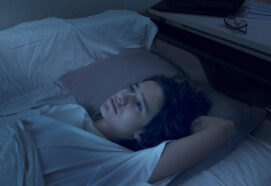 teenage boy suffering from insomnia lying in bed at night.