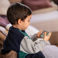 Young Child Engaged with a Mobile Device, Exploring Digital Content