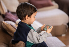 Young Child Engaged with a Mobile Device, Exploring Digital Content