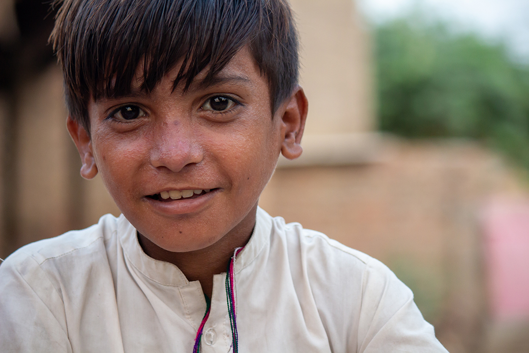 A smiling young boy in a refugee camp.