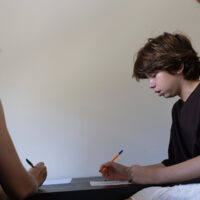 Teacher helping student with learning difficulties doing homework