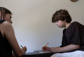 Teacher helping student with learning difficulties doing homework