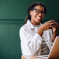 happy smiling black woman working on laptop