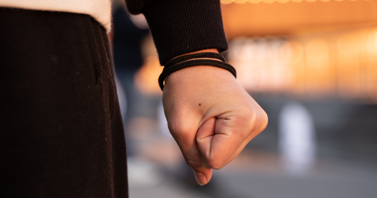 The clenched fist of a teenage girl, clench fists angry grimacing evil hateful face, pressured, hate unfair results