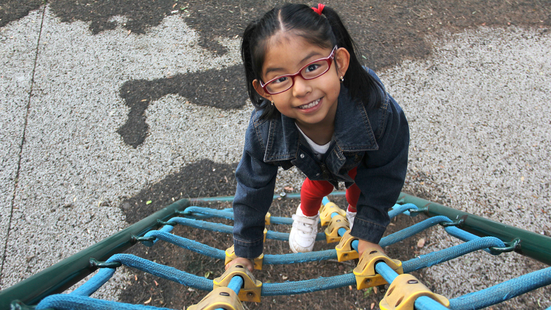  Latina brunette girl with eye glasses plays in the playgroud