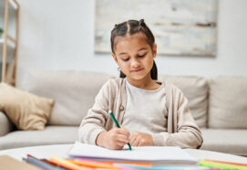 young girl drawing at a desk