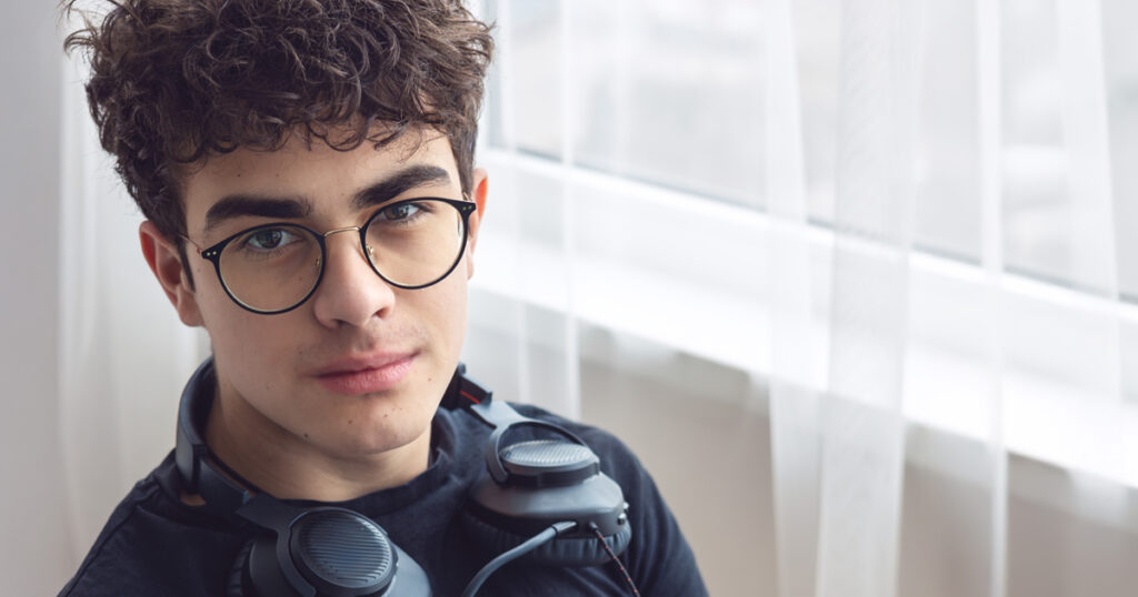 Teenage Boy with Glasses and Headphones – Modern Youth, Gaming, Technology, Online Learning, Social Media, Mental Health, ADHD, Concentration Issues, Self-Identity, Gen Z Lifestyle. copyspace