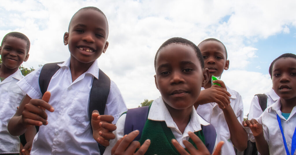 happy black African kids in school uniforms, smiling and enjoying a break. A positive image of youth, education, diversity, and community spirit.