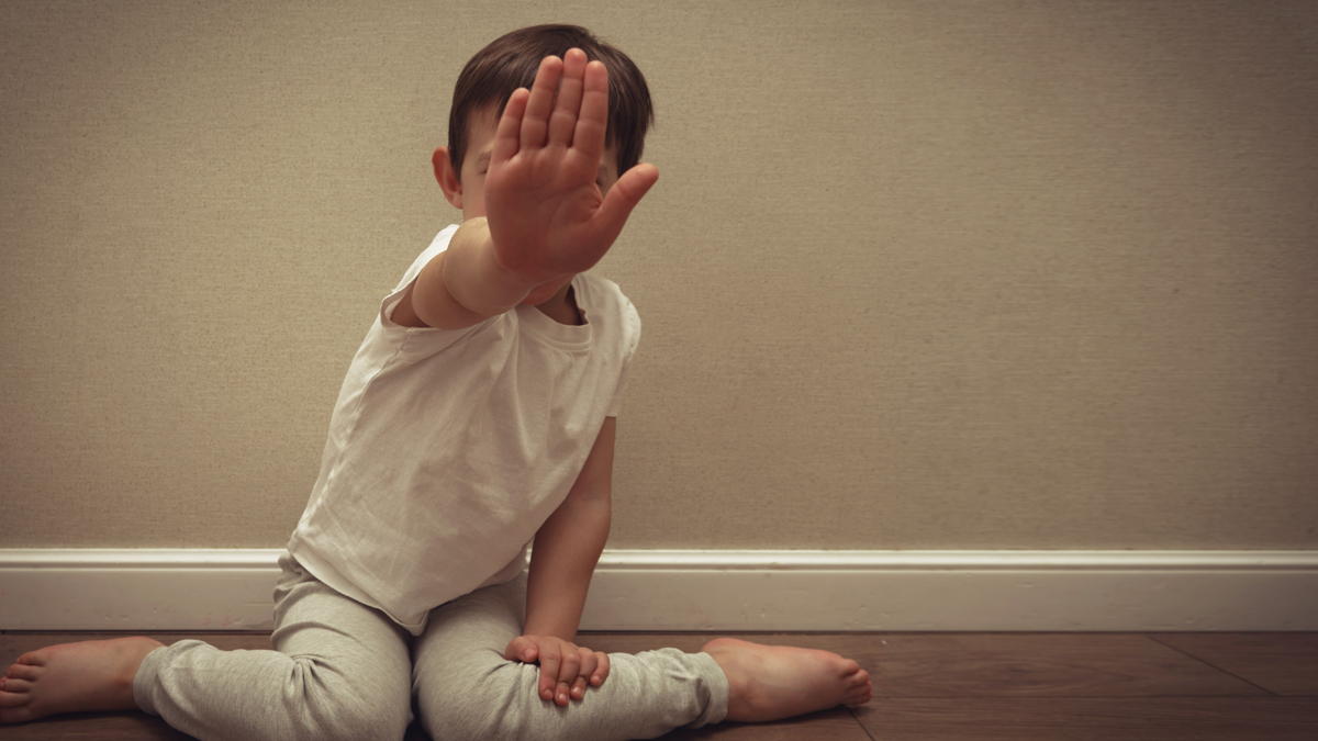 Child making a stop gesture with hand, copy space. Concept of domestic abuse, child protection, and child abuse. For social issues and awareness campaigns.