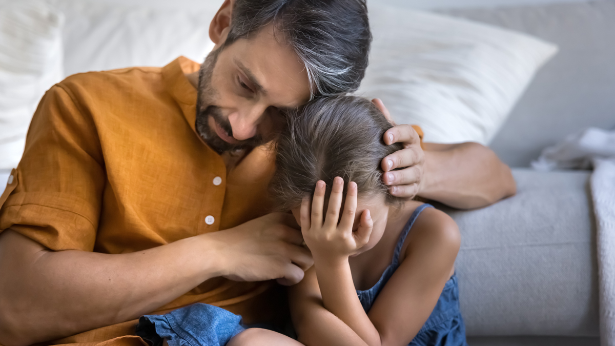 Grieving suffering dad hug upset depressed tween daughter crying on floor at home offer support comfort in difficult moment of losing beloved person coping with parents divorce separation.