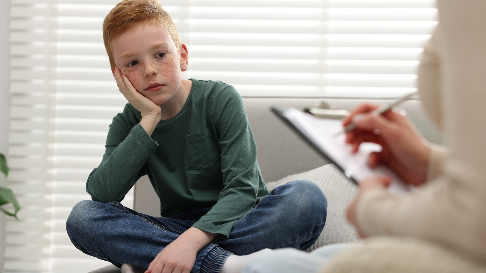 child psychologist working with boy on sofa child psychologist working with boy on sofa