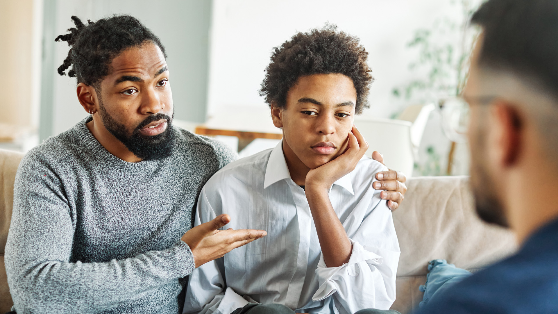 Father with his teenage son at meeting with psychologist discussing mental health Father with his teenage son at meeting with psychologist discussing mental health