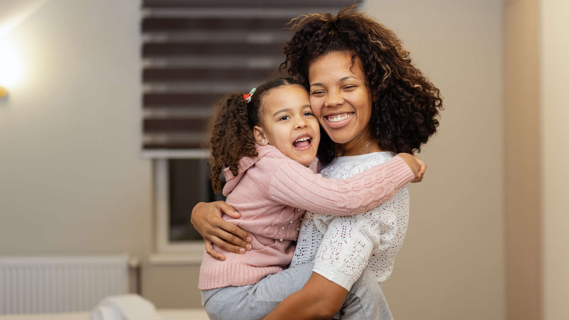 Portrait of happy mother and daughter hugging each other in bedroom at home Portrait of happy mother and daughter hugging each other in bedroom at home