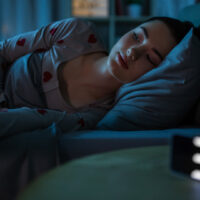 awake teenage girl lying at home at night