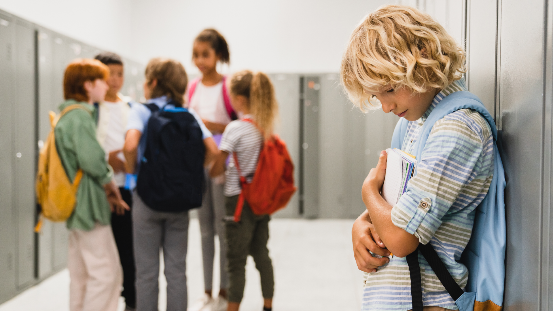 Sad-looking schoolboy stood alone, while all his classmates ignoring him. Sad-looking schoolboy stood alone, while all his classmates ignoring him.